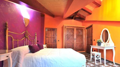 a bedroom with a bed and a colorful wall at Hotel Casa Rural SPA La Villa in Ávila