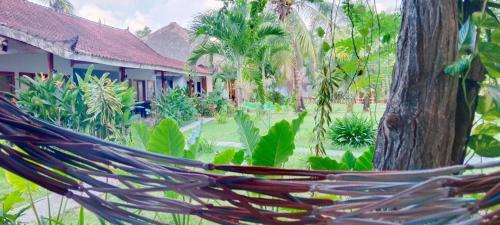 a hammock in front of a resort at Mengalung Bungalow in Kuta Lombok