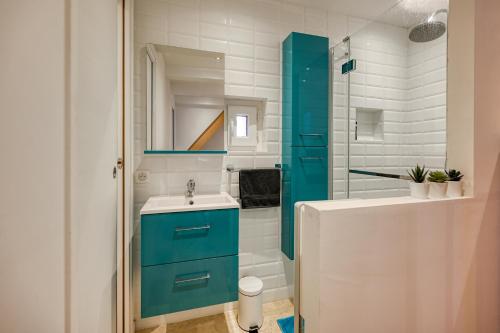 a bathroom with a blue cabinet and a sink at Maison de village au cœur de Lourmarin in Lourmarin