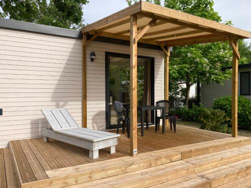 pérgola de madera con mesa y banco en la cubierta en Cottage 2 pers KEY WEST Premium, en Hourtin