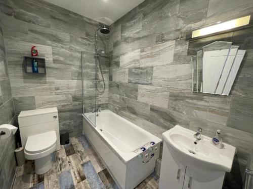 a bathroom with a toilet and a sink and a tub at Driftwood Seagrass in Par