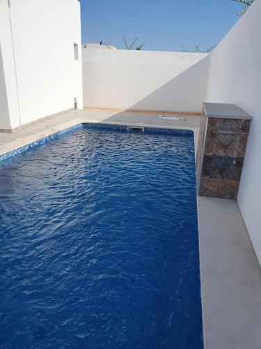 a swimming pool with blue water in a room at Villa de luxe avec piscine sans vis à vis Midoun in Aghīr