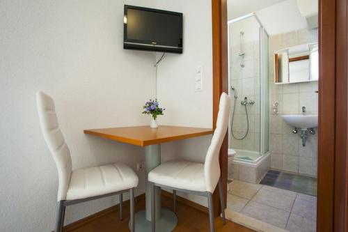 a bathroom with a table and two chairs and a television at Apartments by the sea Drasnice, Makarska - 6697 in Drasnice