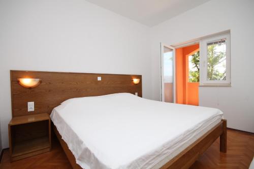 ein Schlafzimmer mit einem großen weißen Bett und einem Fenster in der Unterkunft Rooms by the sea Metajna, Pag - 6487 in Metajna