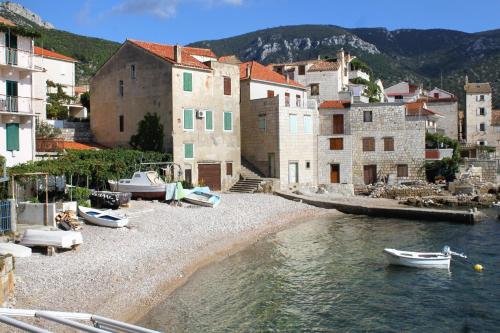 a group of buildings and boats on the water at Apartments by the sea Komiza, Vis - 2429 in Komiža