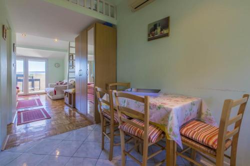 a dining room with a table and chairs and a living room at Apartments by the sea Selce, Crikvenica - 4802 in Selce
