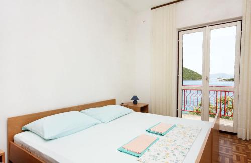a bedroom with a bed and a large window at Seaside holiday house Prozurska Luka, Mljet - 4946 in Prožura
