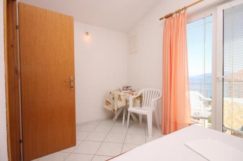 um quarto com uma mesa, uma cadeira e uma janela em Apartments by the sea Podaca, Makarska - 6745 em Podaca