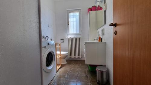 uma casa de banho com uma máquina de lavar roupa e um WC em Villa Duino Trieste Reception em Duino