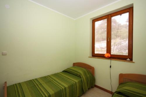um quarto com uma cama e uma janela em Seaside holiday house Tisno, Murter - 5094 em Tisno
