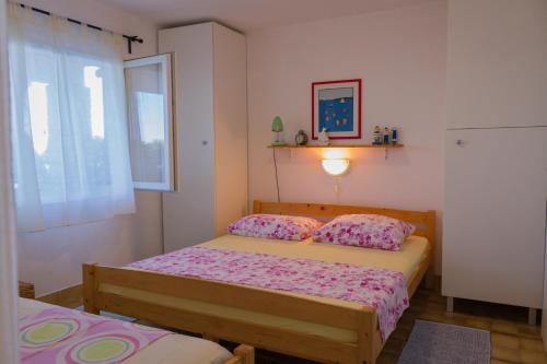 1 dormitorio con 2 camas y ventana en Apartments by the sea Stomorska, Solta - 5190, en Stomorska