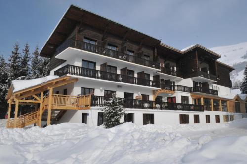 un edificio en la nieve con nieve alrededor en Hôtel Valentin en Les Deux Alpes