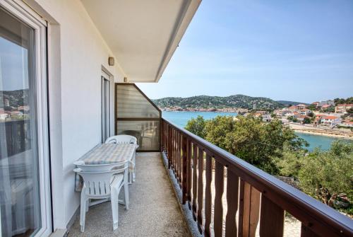 a balcony with a table and chairs and a view of the water at Apartments and rooms by the sea Tisno, Murter - 5128 in Tisno