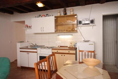 a kitchen with white cabinets and a table and a microwave at Holiday house with a parking space Sali, Dugi otok - 8138 in Sali