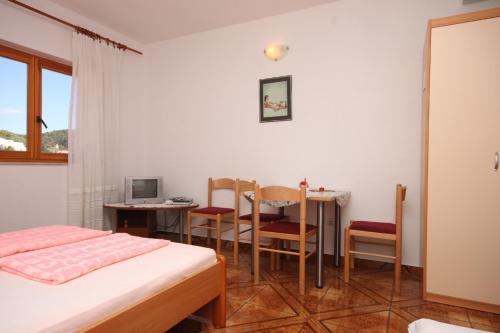 a room with a bed and a table and chairs at Apartments by the sea Zivogosce - Porat, Makarska - 6699 in Igrane