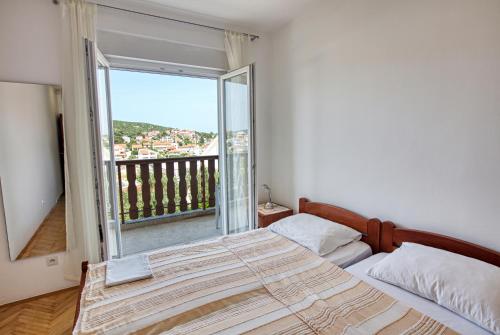 una camera con un letto e una grande finestra di Apartments and rooms by the sea Tisno, Murter - 5128 a Tisno (Stretto)