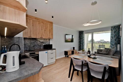 a kitchen and living room with a table and chairs at BlueApart Apartamenty Na Klifie in Władysławowo