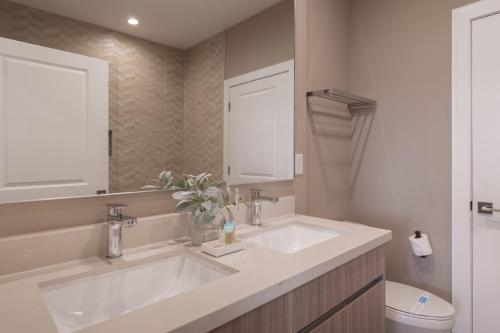 een badkamer met 2 wastafels en een toilet bij Beautiful townhome Magic Village 1,5 mile to Dis in Orlando