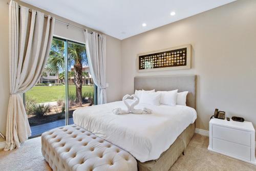 een slaapkamer met een groot bed en een groot raam bij Beautiful townhome Magic Village 1,5 mile to Dis in Orlando