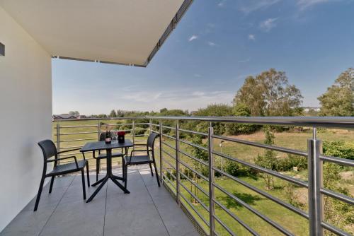 a balcony with a table and chairs and a view of a field at BlueApart Apartamenty Na Klifie in Władysławowo