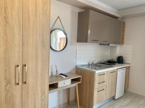 a small kitchen with a sink and a mirror at THOMAS STUDIOS & APARTMENTS PARALIA in Paralia Katerinis