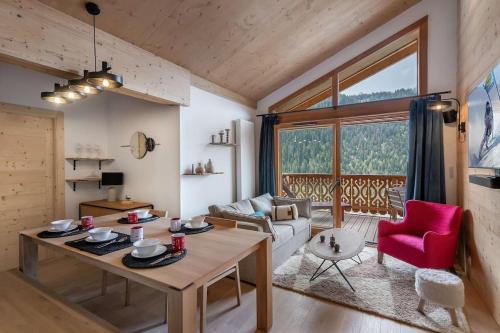 un salon avec une table et une chaise rouge dans l'établissement Perle de Savoie - A402 - Châtel - Multipass 2025 offert, à Châtel