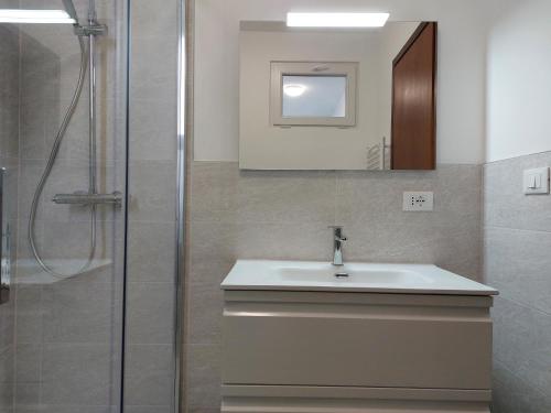 La salle de bains est pourvue d'un lavabo et d'une douche. dans l'établissement Appartamento Codroipo Centrale, à Codroipo