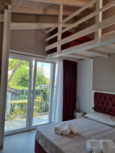 a bedroom with a bed and a large sliding glass door at Blue Inn Residence e B&B in Lido delle Nazioni