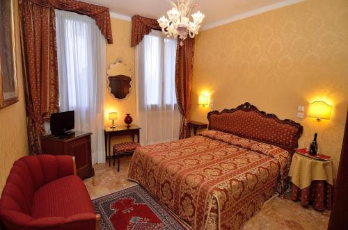 a bedroom with a bed and a chair and a television at Hotel Da Bruno in Venice