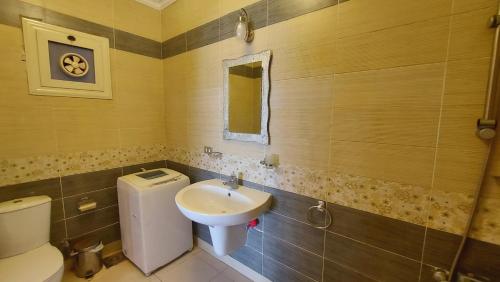 La salle de bains est pourvue de toilettes et d'un lavabo. dans l'établissement Cheerful Villa - Romance Resort, à Ain Sokhna