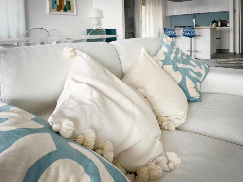 a pile of pillows on a white couch at Mareincasa in Aci Castello