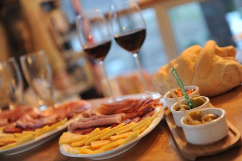 a table with two plates of food and glasses of wine at Terral Suites in Mar de las Pampas