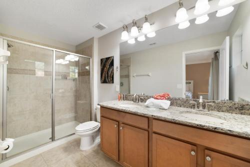 a bathroom with a toilet and a sink and a shower at Paradise Villa Disney Staycation Pool, Fun & Resort Access in Kissimmee