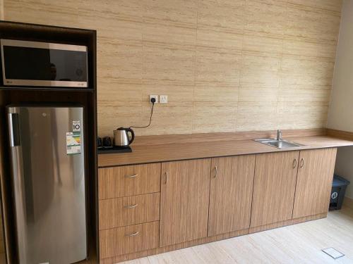 a kitchen with a counter with a sink and a refrigerator at Half Moon Al Khobar Resort in Half Moon Bay