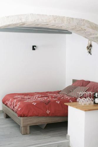 - une chambre avec un lit rouge dans un mur blanc dans l'établissement Rully house, à Rully