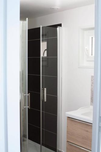 La salle de bains est pourvue d'un lavabo et d'une porte de douche en verre. dans l'établissement Rully house, à Rully