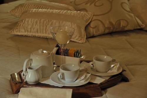 uma bandeja com chávenas de chá e pires numa cama em Hotel Parco em Castelvetro Piacentino