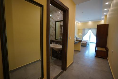 La salle de bains est pourvue d'un lavabo et d'un miroir. dans l'établissement Counsel Beach Hotel New Alamein, à El Alamein