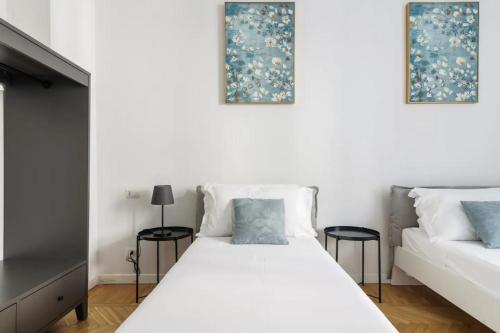 ミラノにあるLuxury 4 bedrooms apartments Close to Duomoの白いベッド(テーブル2台付)