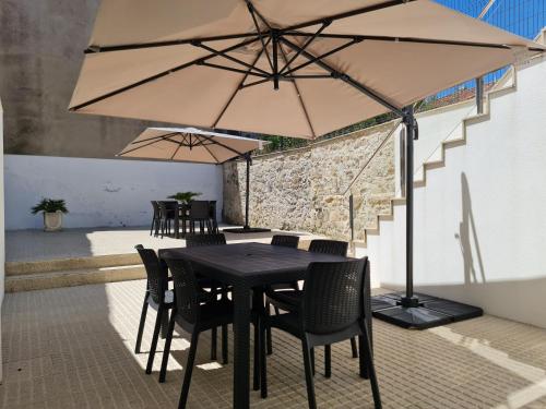 a table with chairs and an umbrella on a patio at Apartamentos Castelo in Póvoa de Varzim