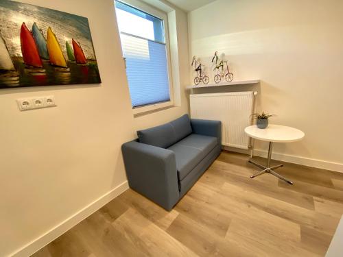 a living room with a blue couch and a table at Haus am Iberg 4 in Willingen