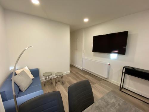 a living room with a blue couch and a flat screen tv at Haus am Iberg 4 in Willingen