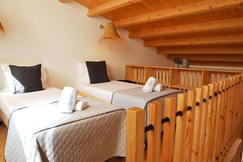 3 Betten in einem Zimmer mit Holzdecken in der Unterkunft Patio de Agua de Alvor in Alvor