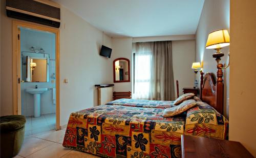 a hotel room with a bed and a sink at Hotel BONCOMPTE in Ponts