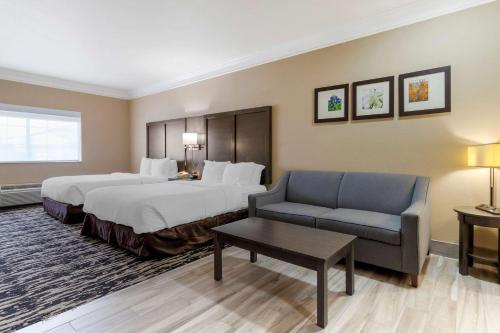 Habitación de hotel con 2 camas y sofá en Comfort Suites Kingwood Humble Houston North, en Humble