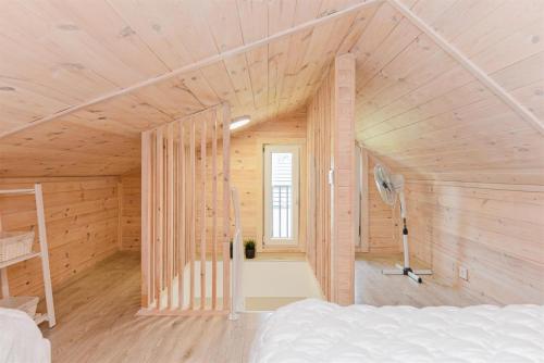 a bedroom in a wooden house with a bed at Vila „Prie tvenkinio“ in Palanga