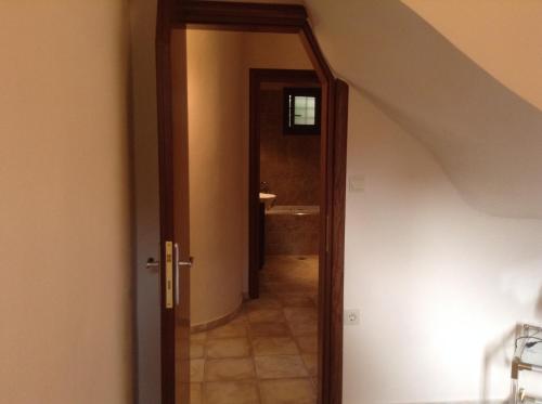 a hallway with a door leading to a bathroom at Pilion Stone House in Áyios Vlásios