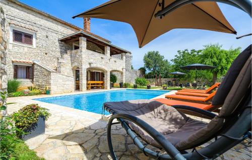 a swimming pool with a chair and an umbrella at Amazing Home In Svetvincenat With Wifi in Svetvinčenat