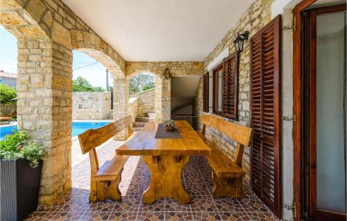 an outdoor patio with a wooden table and benches at Amazing Home In Svetvincenat With Wifi in Svetvinčenat