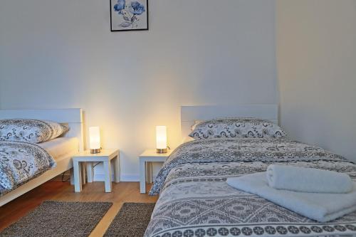 a bedroom with a bed and two night stands with lamps at Apartman F&F 2 in Otočac